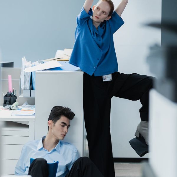 Man sitting at a desk and stretching his back slightly.